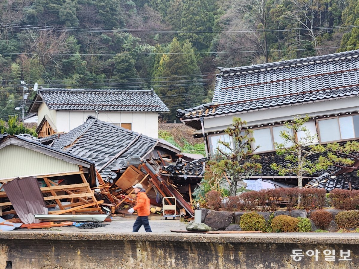 3일 일본 이시카와현 노토반도 아나미즈정의 무너진 가옥 앞을 한 행인이 걸어가고 있다. 아나미즈=이상훈 특파원 sanghun@donga.com