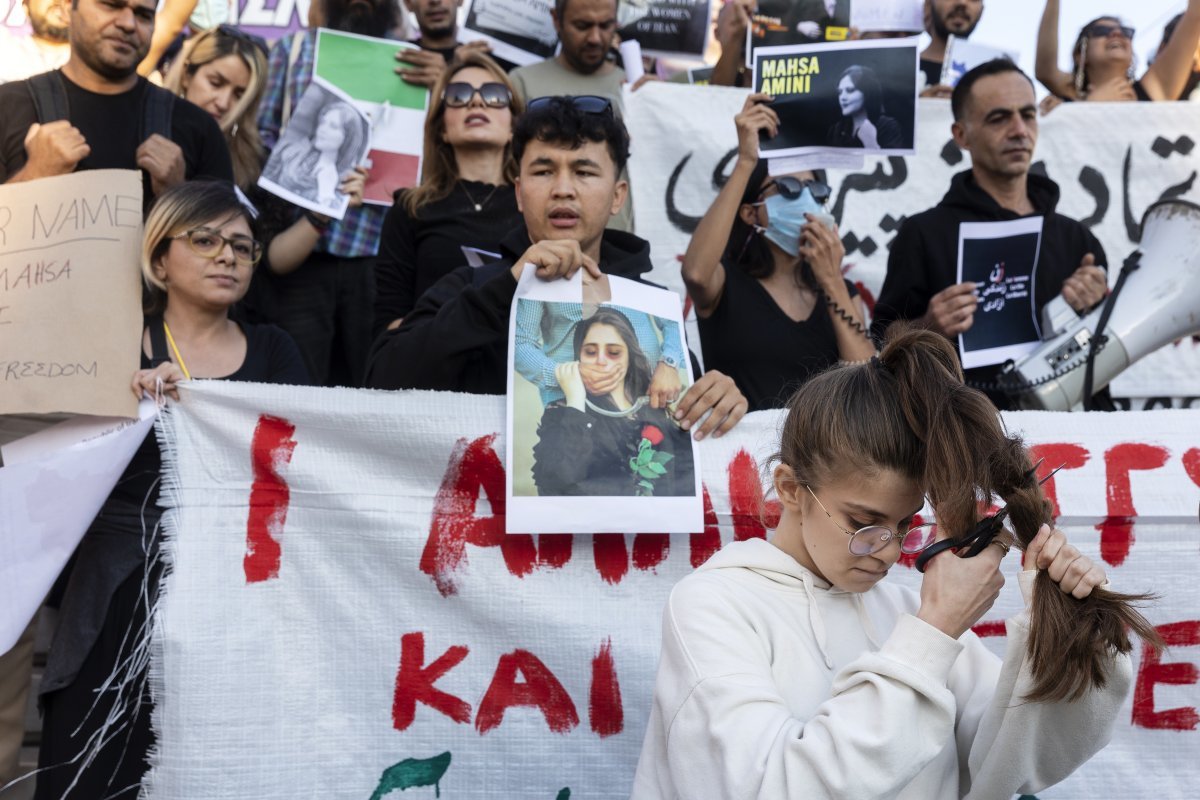 2022년 9월24일 그리스 아테네 산타그마 광장에서 히잡 착용 불량으로 체포된 뒤 의문사한 ‘마사 아미니 사망 사건’의 진상 규명을 촉구하는 22세 이란 여성이 ‘히잡 착용 불량’으로 체포된 후 의문사한 사건의 진상 규명을 촉구하는 시위가 열렸다. 시위에 참가한 한 여성이 항의 표시로 머리카락을 자르고 있다. 아테네=AP 뉴시스
