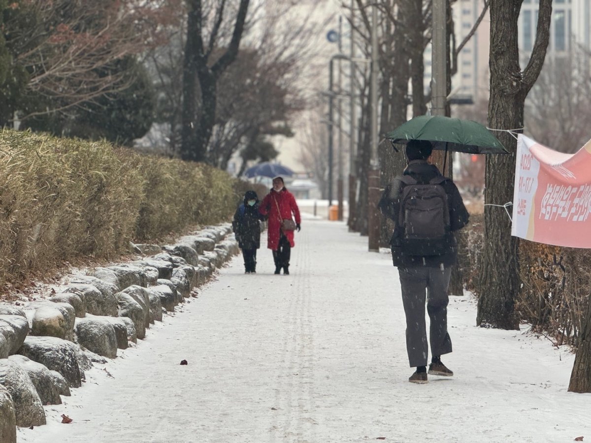 눈이 내리는 9일 오전 인천시 남동구 인천시청 앞에서 시민들이 우산을 쓰고 발걸음을 옮기고 있다. 이날 오전 옹진군을 제외한 인천에는 대설주의보가 내려졌다. 2024.1.9 뉴스1
