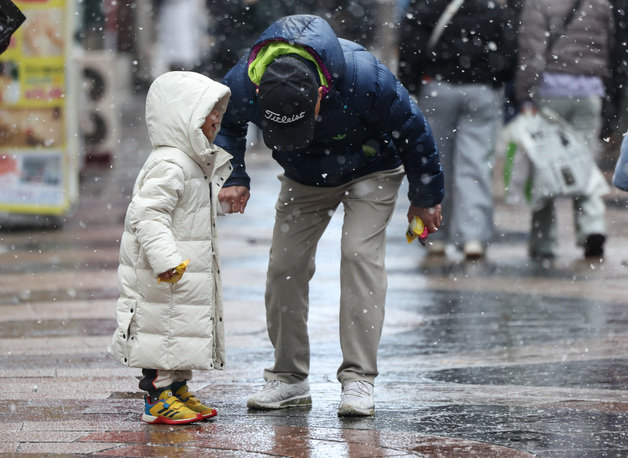 전국에 많은 눈이 내리는 9일 오후 서울 중구 명동 거리에서 할아버지와 손자가 얘기를 하고 있다. 2024.1.9 뉴스1