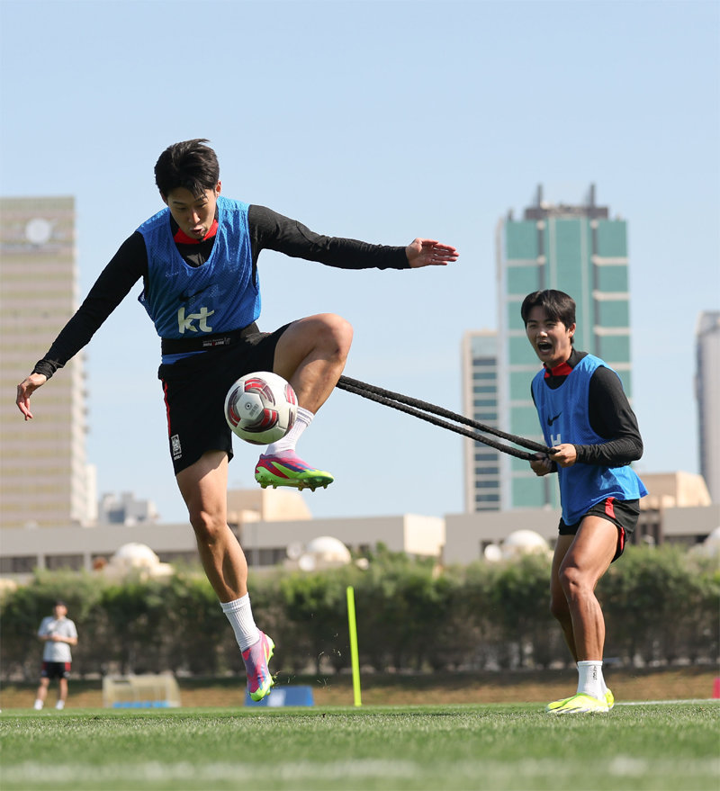 한국 축구대표팀의 주장 손흥민(왼쪽)이 카타르 도하 훈련캠프에서 설영우와 함께 훈련하고 있다. 설영우가 허리에 묶은 줄을 잡아당겨
 무게중심을 흔드는 가운데서도 손흥민은 볼을 잡아내고 있다. 한국은 15일 바레인과 아시안컵 조별리그 첫 경기를 치른다. 
대한축구협회 제공