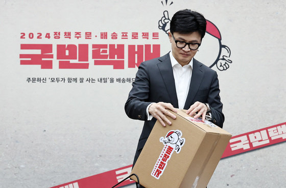 한동훈 국민의힘 비상대책위원장이 15일 오후 서울 여의도 국회에서 열린 제22대 총선 공약개발본부 출범식에서 ‘국민택배 정책배송’ 퍼포먼스를 마친 뒤 상자를 뜯어보고 있다. 2024.1.15 뉴스1