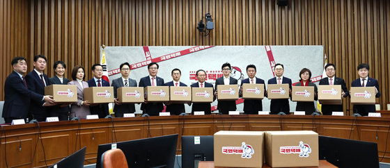 국민의힘 한동훈 비상대책위원장과 윤재옥 원내대표, 유의동 정책위의장 등 참석자들이 15일 오후 서울 여의도 국회에서 열린 제22대 총선 공약개발본부 출범식에서 ‘국민택배 정책배송’ 퍼포먼스를 하고 있다. 2024.1.15 뉴스1