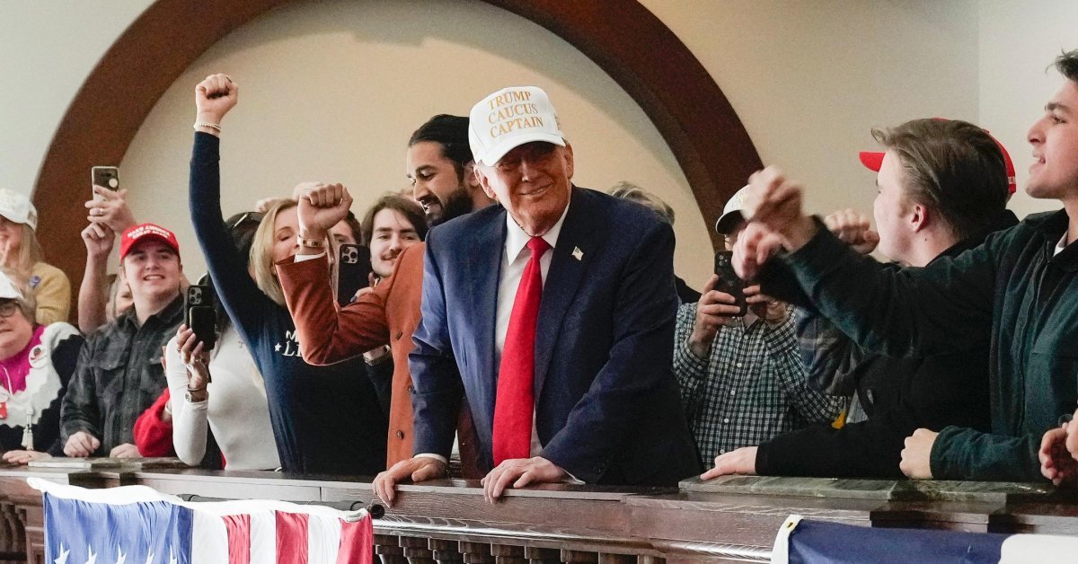 14일(현지 시간) 미국 아이오와주 디모인의 한 호텔에서 열린 선거 유세에서 도널드 트럼프 전 대통령(가운데)이 ‘트럼프는 
코커스의 캡틴(Trump caucus captain)’이라 적힌 흰 모자를 쓰고 지지자들을 향해 웃어 보이고 있다. 15일 
아이오와주에서는 11월 대선에 도전할 공화당 대선 후보 선출을 위한 첫 코커스(당원대회)가 열린다. 디모인=AP 뉴시스