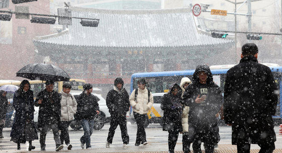 전국 대부분 지역에 눈이 내릴 것으로 예보된 17일 오후 서울 종로구 종로1가 사거리에서 시민들이 함박눈을 맞으며 이동하고 있다. 2024.1.17/뉴스1