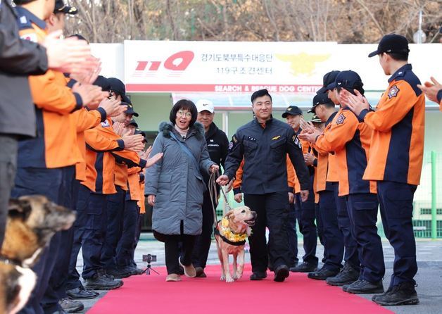 19일 경기도북부특수대응단 119구조견센터에서 열린 구조견 ‘아롱’의 은퇴식. 구조대원들의 축하를 받으며 ‘아롱’이 행사장을 나서고 있다. (경기도 제공)