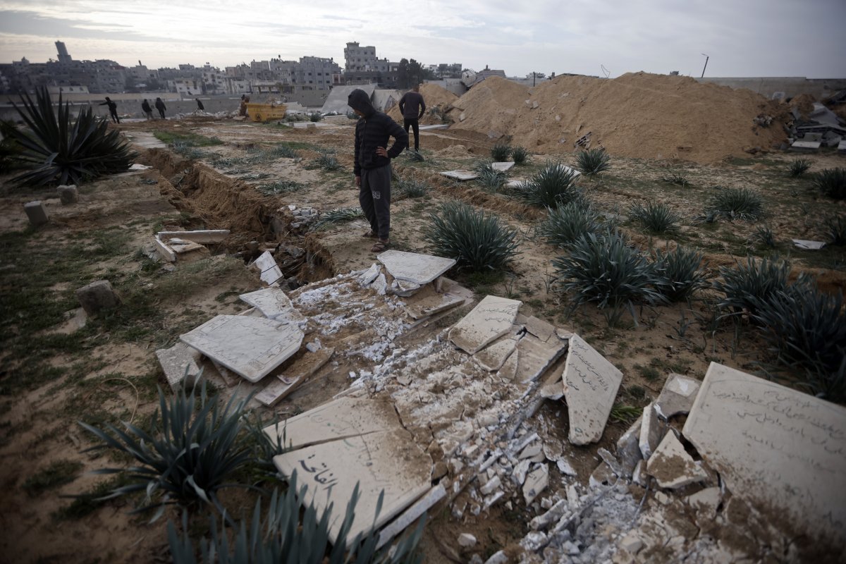 17일(현지시각) 가자지구 칸유니스 난민 캠프에서 팔레스타인인들이 이스라엘군 전차의 습격으로 손상된 묘지를 살펴보고 있다. 사잔=AP 뉴시스