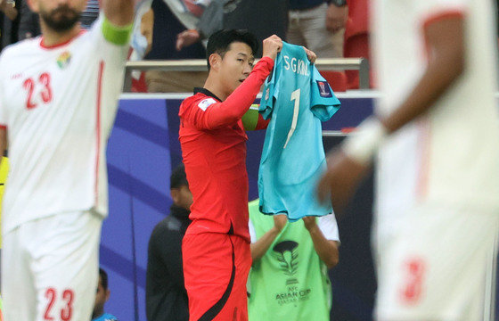 대한민국 축구대표팀 손흥민이 20일(현지시간) 카타르 도하 알투마마 스타디움에서 열린 2023 아시아축구연맹(AFC) 카타르 아시안컵 조별리그 E조 조별리그 2차전 요르단과 대한민국의 경기에서 페널티킥을 넣은 후 부상으로 소집해제 된 김승규의 유니폼을 들고 있다. 2024.1.20 뉴스1