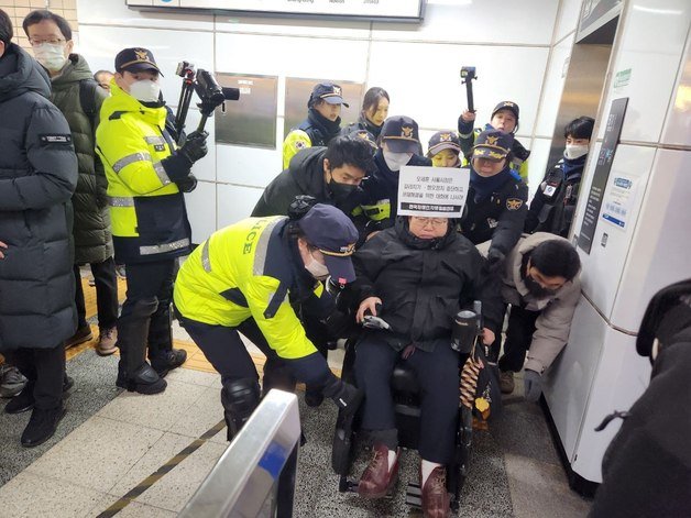 22일 오전 8시30분쯤 서울 지하철 4호선 혜화역에서 이형숙 공동대표가 경찰에 연행되고 있다. (전장연 제공)