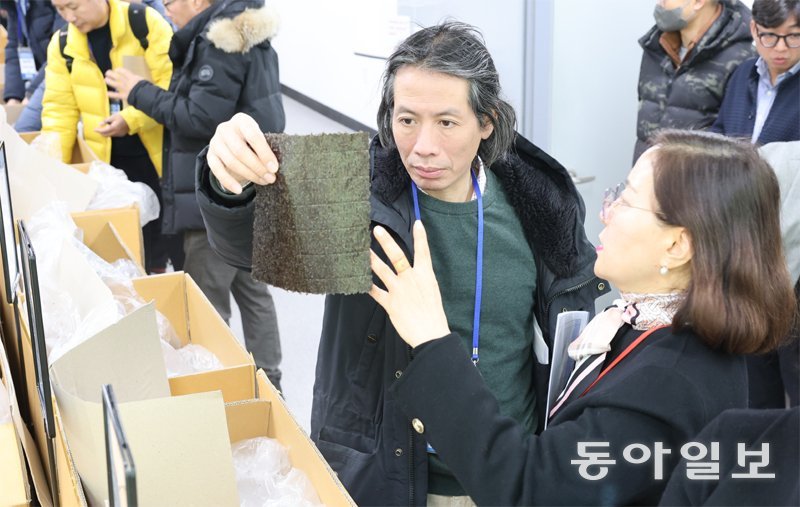 충남 서천군에 전국 최초로 문을 연 ‘국제 마른김 거래소’를 23일 찾은 해외 바이어가 마른김을 들고 직원의 설명을 듣고 있다. 
전날 개소식을 열고 본격적인 운영에 들어간 마른김 거래소에는 이틀 동안 50여 명의 해외 바이어가 방문해 첫 계약이 성사됐다. 
서천=이정훈 기자 jh89@donga.com