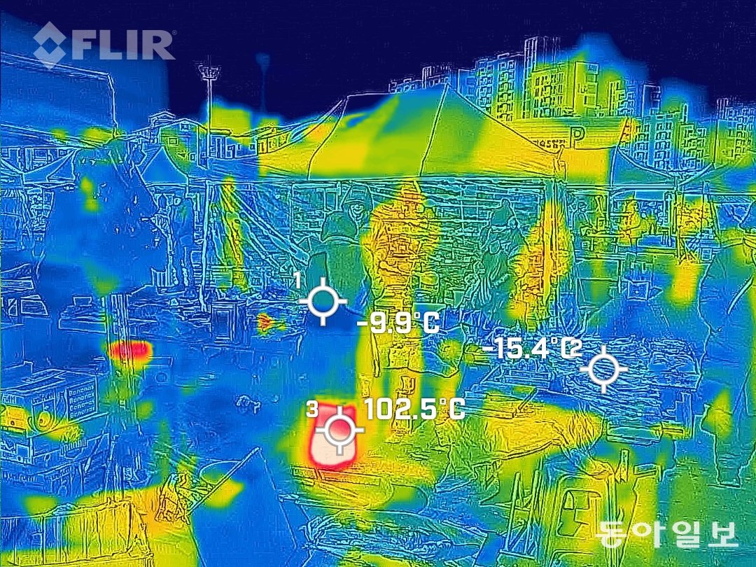 24일 경기도 성남시 모란민속5일장에서 열화상 카메라로 본 화면이 난로 부분을 제외하고는 온통 파랗다. 생선은 영하 15도를, 상인은 영하 10도를 나타냈다. 성남=이한결 기자 always@donga.com
