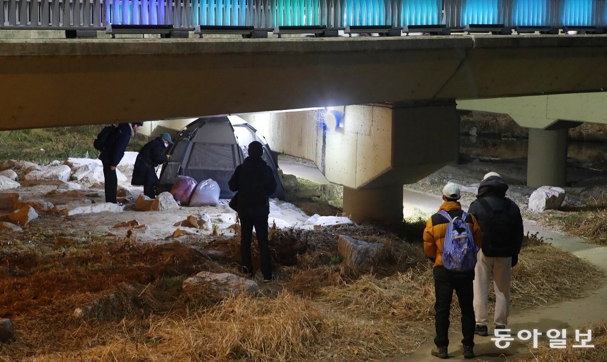 지난달 29일 대전시노숙인종합지원센터 관계자들이 대전 동구 삼성동 북부교 아래 텐트에서 10년 넘게 노숙하고 있는 남성에게 김밥과 생수, 핫팩을 전달하고 있다. 김태영 기자 live@donga.com