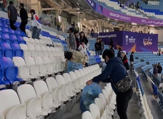 ‘2023 아시아축구연맹(AFC) 아시안컵 카타르’ 8강전이 끝나고 한국팬들이 경기장 쓰레기를 줍고 있는 모습. ‘알 카스 티브이’ X(트위터) 영상 캡처