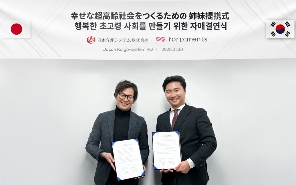 일본 개호시스템㈜ 오토모 토시오 대표(왼쪽)와 포페런츠 장준표 대표가 오사카에 위치한 일본개호시스템 본사 회의실에서 협약서를 들고 기념촬영을 하고 있다.