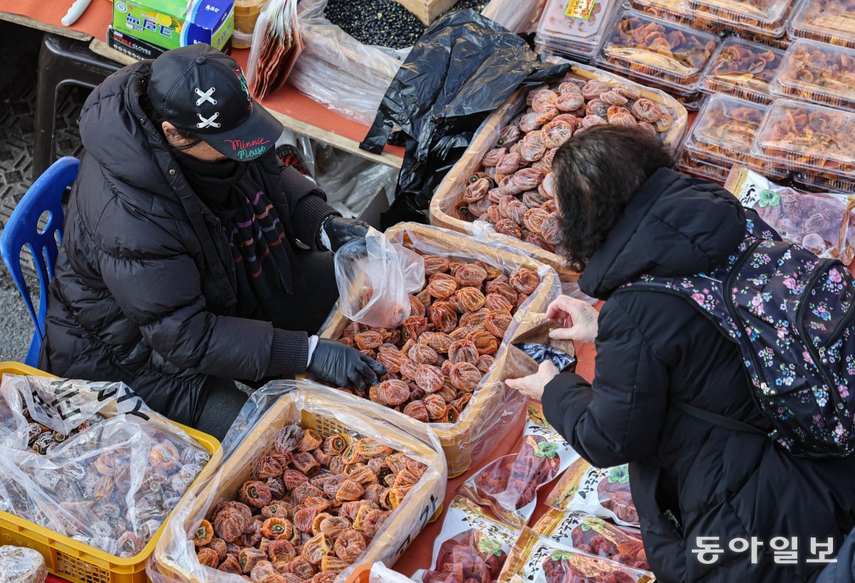 설 명절 연휴를 이틀 앞둔 7일 오전 경북 안동 중앙신시장 오일장에서 한 시민이 곶감을 고르고 있다. 안동=이한결 기자 always@donga.com