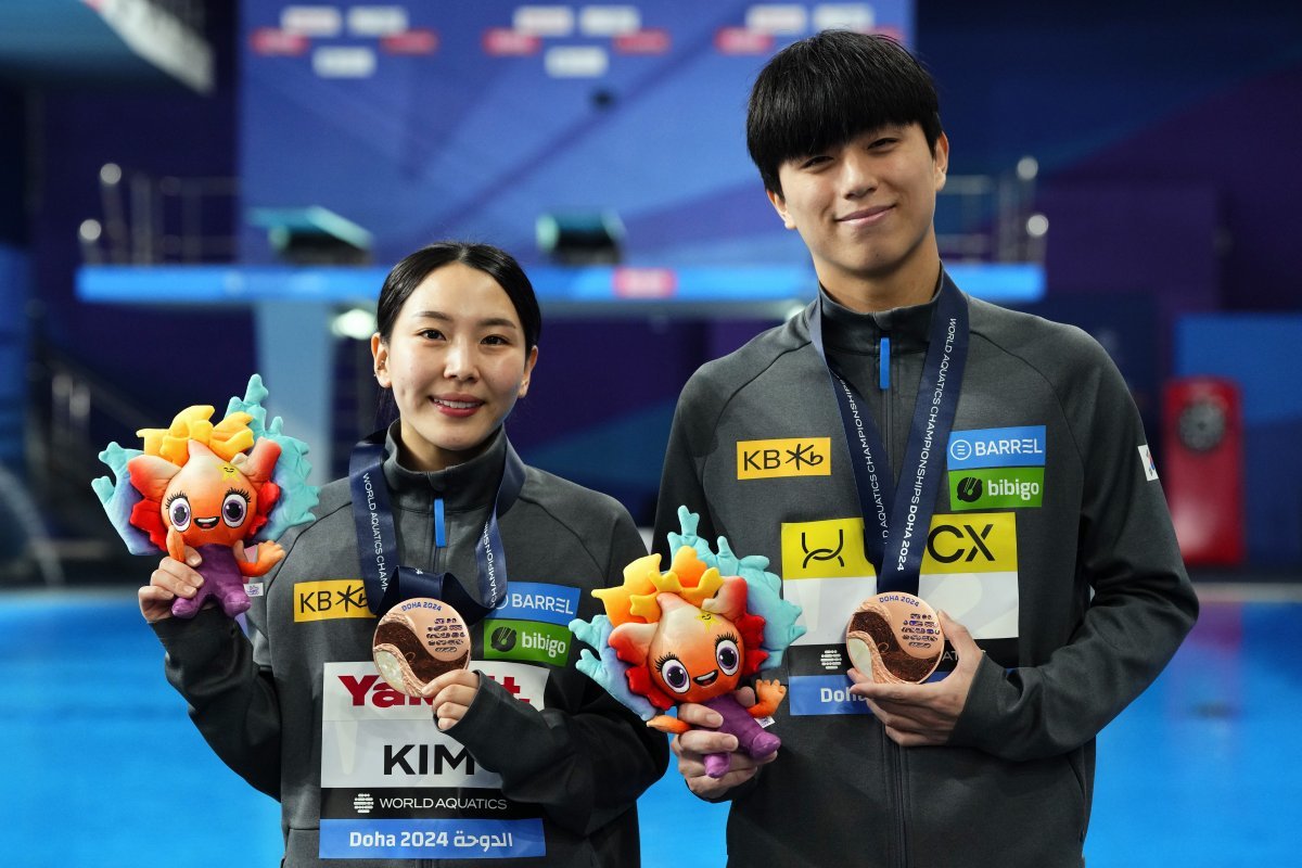 김수지(왼쪽)가 10일 이재경과 짝을 이뤄 출전한 세계수영선수권대회 혼성 싱크로 3m 스프링보드에서 동메달을 목에 건 뒤 카메라 앞에 함께 섰다. 도하=AP 뉴시스