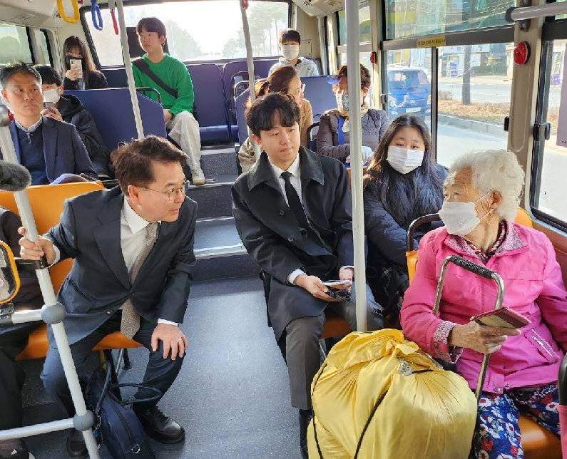 육동한 춘천시장(앞줄 왼쪽)이 지난해 마을버스 노선 개편 이후 버스를 타고 출근하면서 시민들과 버스 이용에 대해 의견을 나누고 있다. 춘천시 제공