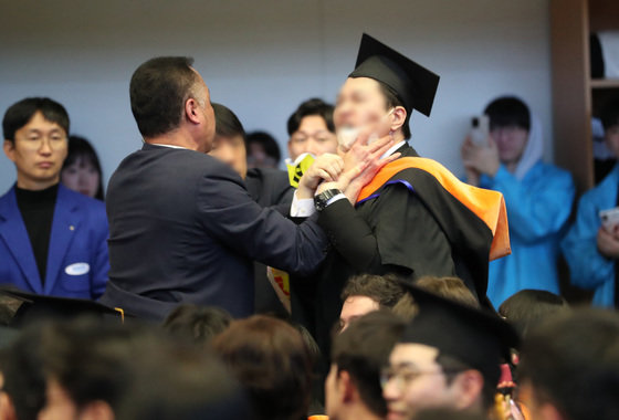 16일 오후 대전 유성구 한국과학기술원(KAIST)에서 열린 2024년 학위수여식에서 한 졸업생이 윤석열 대통령에게 항의하자 경호원들로부터 제지를 당하고 있다. (대전충남공동취재단) 2024.2.16/뉴스1