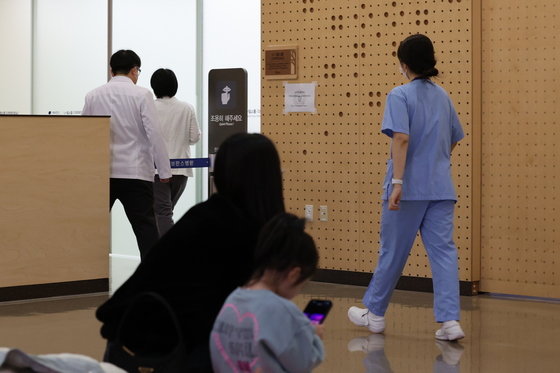 19일 오전 서울 서대문구 연세 세브란스 어린이병원에서 진료를 기다리는 어린이 가족 뒤로 의료진이 지나가고 있다.  2024.2.19/뉴스1 ⓒ News1