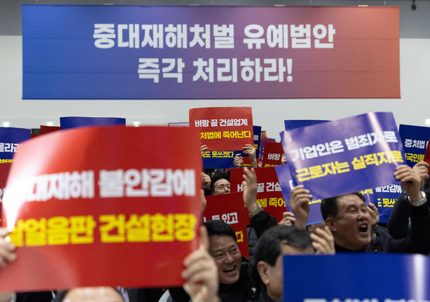 14일 오후 경기도 수원시 권선구 수원메쎄에서 열린 50인 미만 사업장 중대재해처벌법 유예 촉구 결의대회에 참석한 중소기업인들이 손 피켓을 들고 있다. 2024.2.14/뉴스1 ⓒ News1