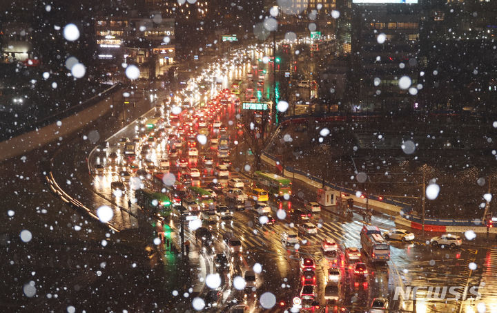 눈이 내리는 21일 서울 광화문 도로에 차량들이 이동하고 있다. 2024.2.21/뉴스1