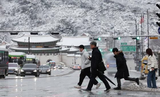 22일 서울 종로구 광화문네거리에서 시민들이 눈 쌓인 도로를 조심스레 걸으며 일터로 향하고 있다. 2024.2.22/뉴스1 ⓒ News1