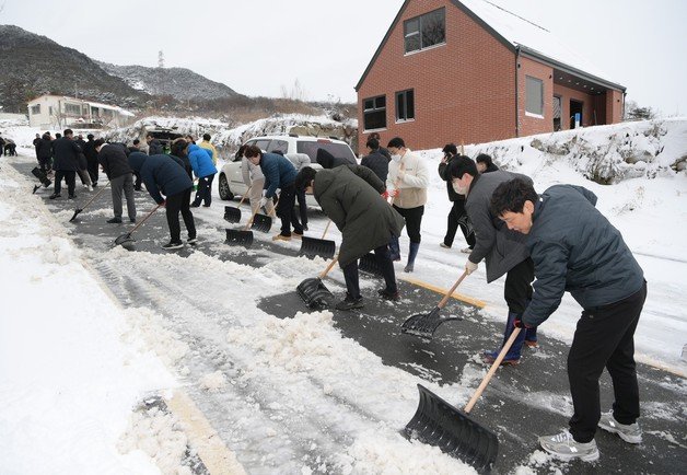 21일 오후 10시쯤 충북 음성군 음성읍 가섭산 송신소 전력 케이블이 폭설로 단선됐다가 약 18시간 만에 복구됐다. 사진은 진입로 제설작업을 하고 있는 음성군 공무원들.(음성군 제공)