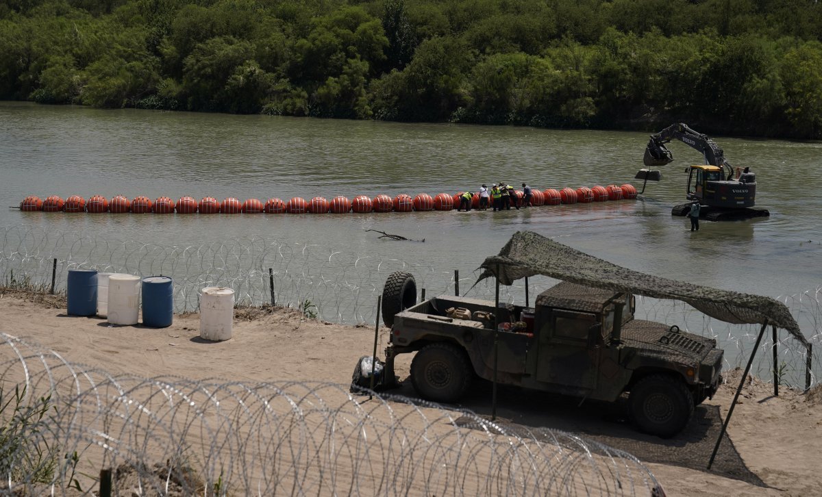 지난해 7월 텍사스주가 리오그란데 강에 설치하는 부표 국경선을 작업자들이 조립하고 있다. 바이든 정부의 법무부는 이를 불법으로 단정하고 그레그 애벗 주지사를 상대로 철거를 요구했다. 이글 패스=AP 뉴시스
