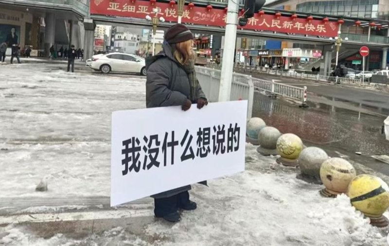 26일 중국 허난성 정저우시의 도심에서 한 여성이 ‘나는 할 말이 없다’라고 적힌 손팻말을 들고서 실시간 온라인 방송을 진행하고 있다. X(옛 트위터) 캡처