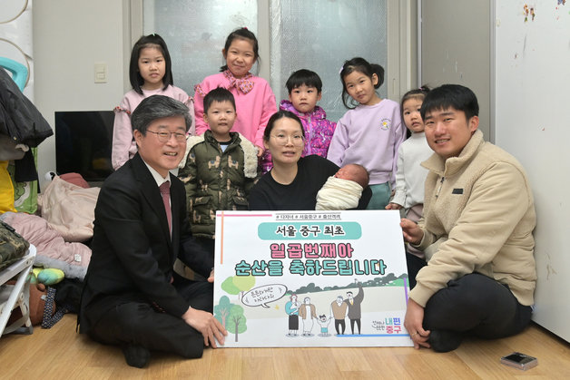 서울 중구에서 이달 일곱 번째 아이를 출산한 부부가 자택으로 방문한 김길성 중구청장(왼쪽)의 축하를 받고 있다. 서울 중구 제공