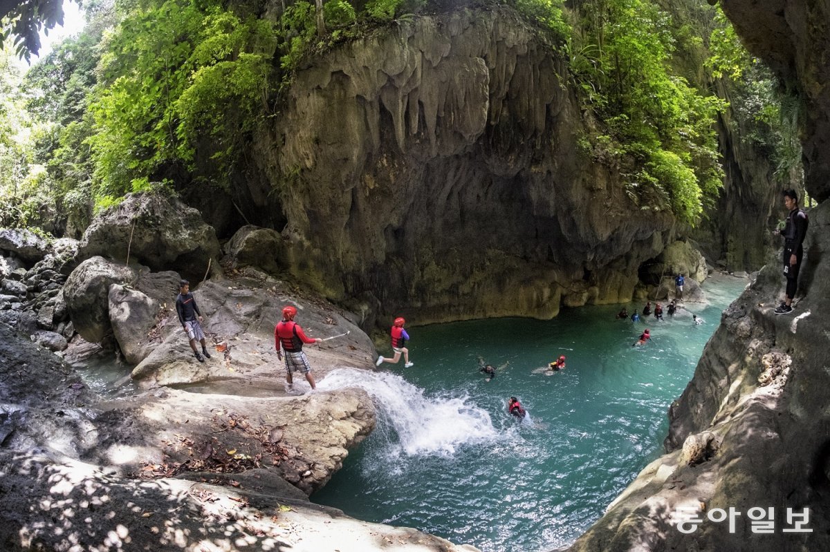 필리핀 세부섬 카와산 폭포 계곡에서 관광객들이 에메랄드빛 계곡물로 뛰어든다. 청정 자연에서 만끽하는 익스트림 레포츠.