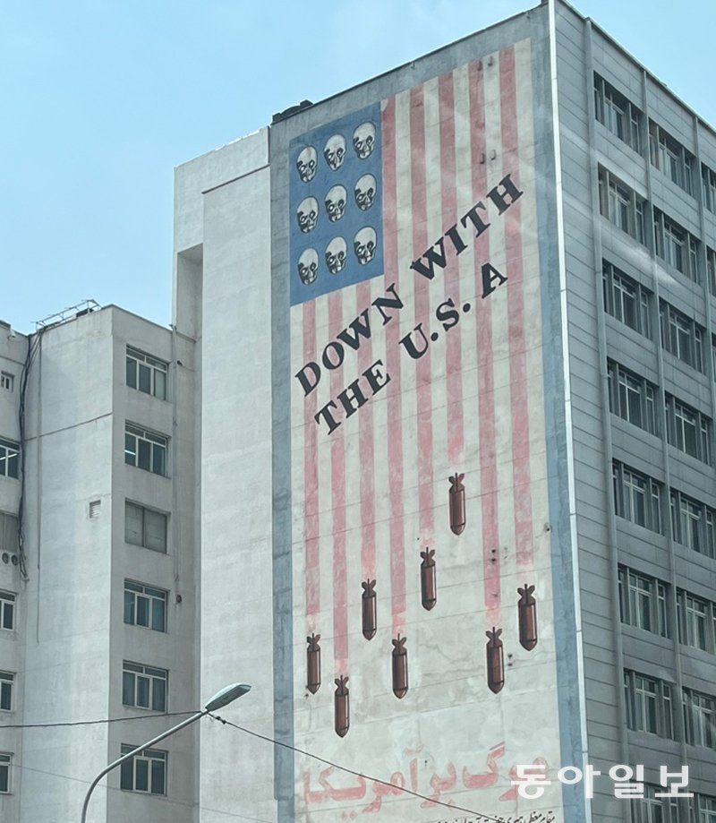 미국 성조기를 타고 흐르는 이란산 미사일 그림에 ‘미국과 함께 추락’이란 영어 문구가 적힌 이란 수도 테헤란의 한 건물 외벽. 테헤란=김기윤 특파원 pep@donga.com