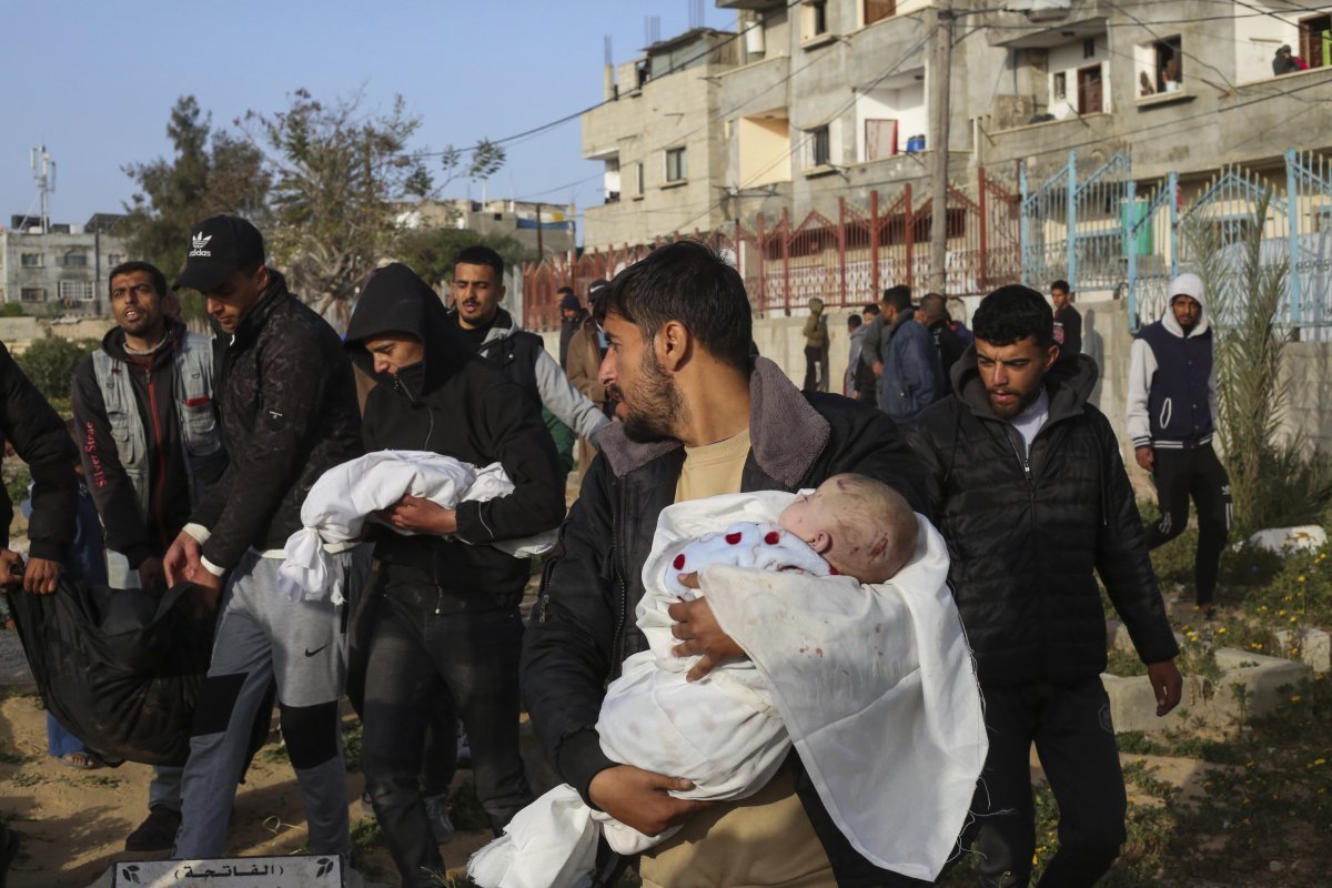 3일(현지시간) 가자지구 라파에서 팔레스타인인들이 이스라엘의 공습으로 숨진 쌍둥이의 시신을 안아 옮기고 있다. 라파=AP/뉴시스