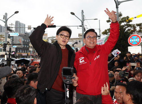국민의힘 한동훈 비상대책위원장(왼쪽)이 5일 충북 청주 상당공원 사거리에서 정우택 의원(청주 상당)과 함께 손을 들어 시민들과 인사를 나누고 있다. 청주=뉴시스