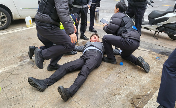 장일 전 당협위원장이 공천심사 결과에 반발해 3일 국민의힘 중앙당사 앞에서 분신을 시도하다 누워있다.  2024.3.3. 뉴스1