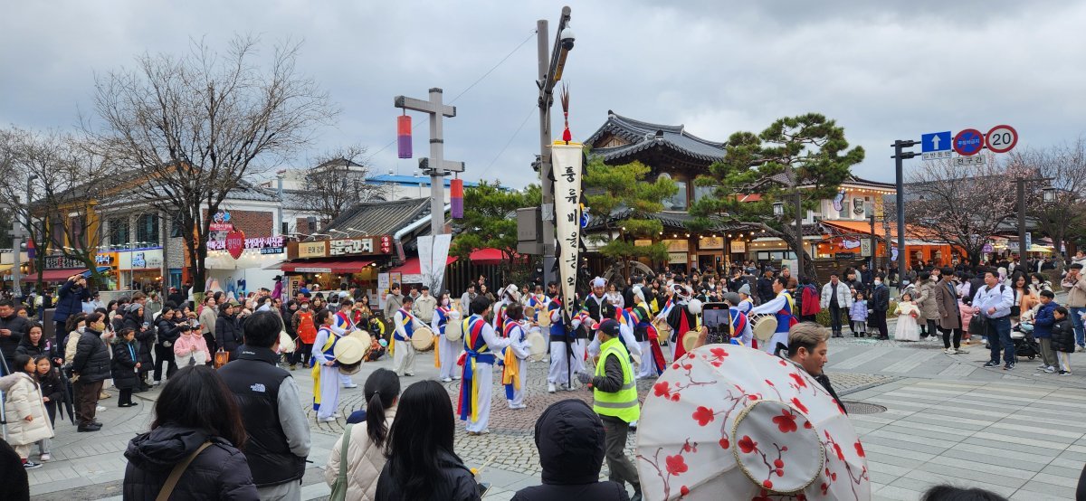 전북 전주시 한옥마을을 찾은 관광객들이 풍물패의 길거리 공연을 보고 있다. 전주한옥마을엔 지난해 1536만4206명이 찾아 역대 최다 방문객 수를 경신한 것으로 집계됐다. 전주시 제공