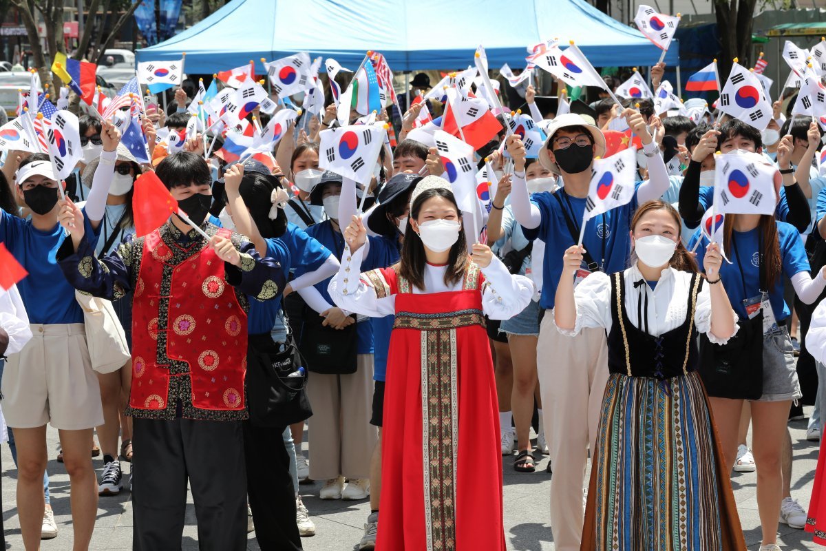 재외동포재단 주최로 열린 ‘대한민국 이민 120주년, 새로운 길을 열다’ 캠페인에 참가한 재외동포 및 대학생들이 풍물놀이를 보며 태극기를 흔들고 있다. 뉴스1