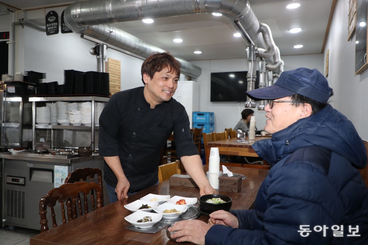 서울시가 쪽방촌 주민들이 저렴하게 식사를 할 수 있도록 ‘동행식당’을 운영 중인 가운데 8일 서울 중구의 신한양식당에서 사장 이진성 씨(39·왼쪽)가 주민에게 식사를 차려주며 웃고 있다. 김동주 기자 zoo@donga.com