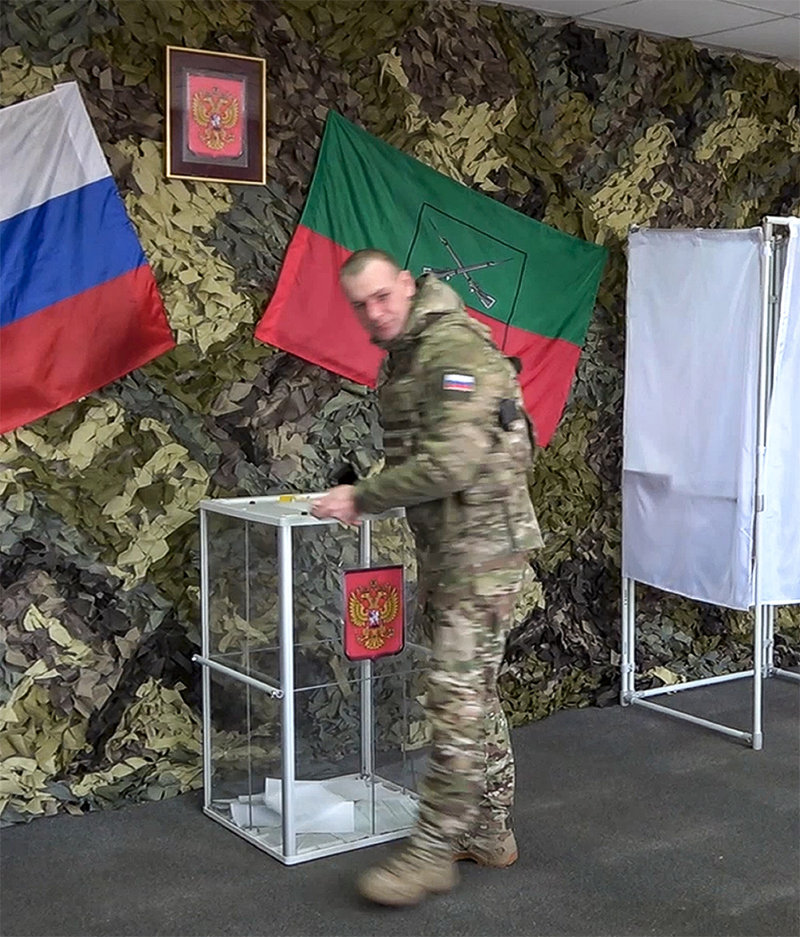 11일 러시아군이 점령 중인 우크라이나 남동부 자포리자의 즉석 투표소에서 15∼17일 실시되는 대통령 선거의 사전 투표에 참가한 러시아 군인. 투표용지가 훤히 들여다보이는 투명 투표함이 눈길을 끈다. 자포리자=AP 뉴시스
