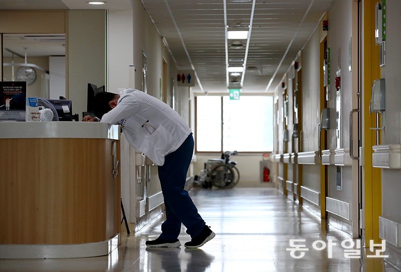 충북대학교병원 85병동에서 한 전문의가 피곤해 서 있는 상태에서 잠시 고개를 숙인 채 엎드려 있다. 전영한 기자 scoopjyh@donga.com
