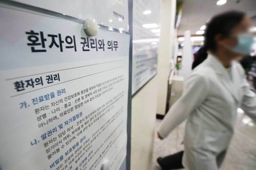 지난 13일 서울시내 병원에서 한 의료진이 ‘환자의 권리와 의무’ 게시물 앞을 지나고 있다. 뉴스1