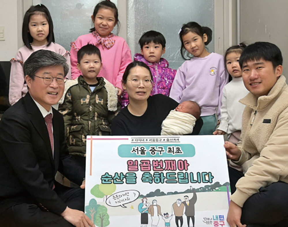 김길성 중구청장(왼쪽)이 일곱 명의 아이를 키우는 부부에게 출산양육 지원금을 건네고 있다. 중구청 제공