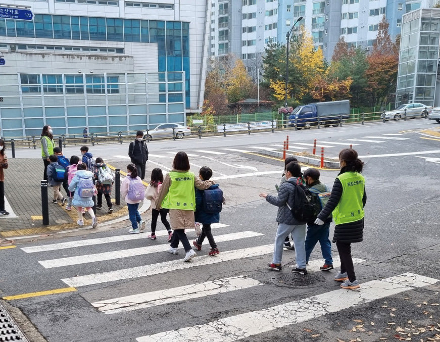 워킹스쿨버스 교통안전지도사가 학생들의 등하교를 안전하게 지도하고 있다. 성동구청 제공