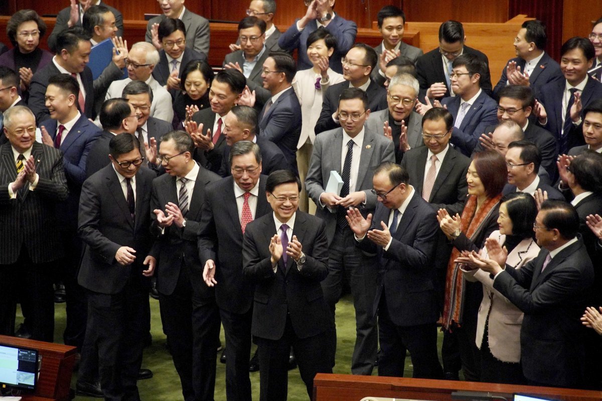 19일 홍콩 입법회(의회)에서 반역 행위에 최고 종신형을 내리는 ‘홍콩판 국가보안법’이 만장일치로 통과되자 존 리 행정장관(앞줄 가운데)이 박수치며 웃고 있다. 홍콩=신화 뉴시스