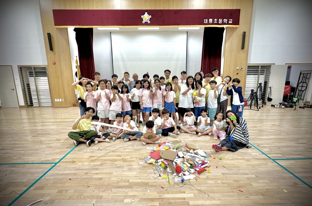 ‘늘봄예술학교’를 촬영한 대룡초등학교에서 최정화 설치미술가와 참여 아이들이 기념사진을 찍고 있다.