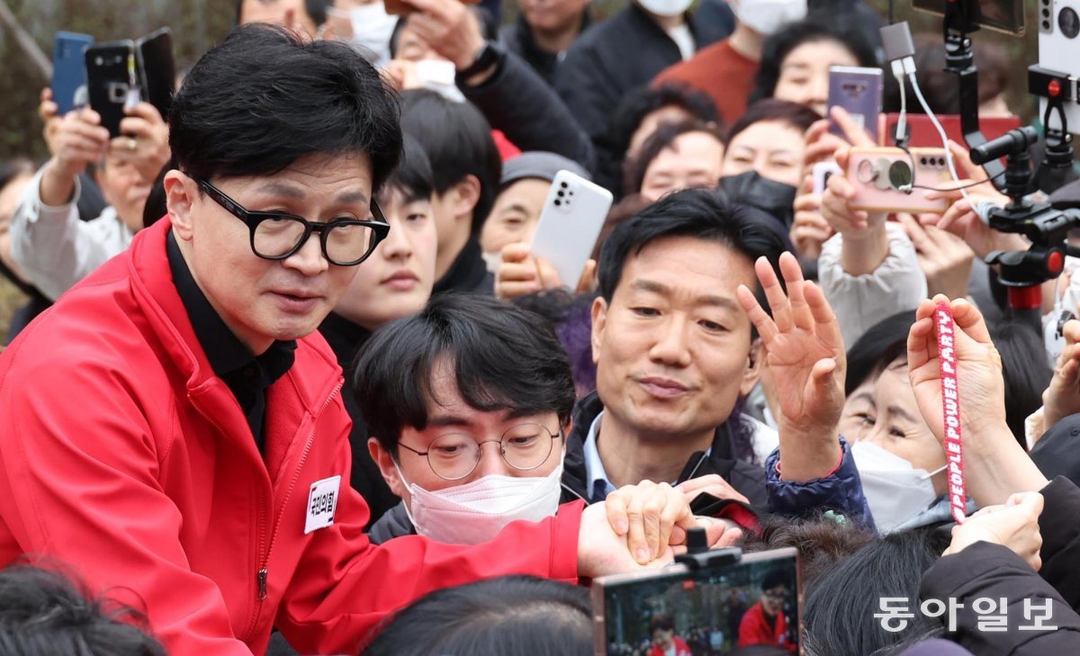 국민의힘 한동훈 비상대책위원장(왼쪽)이 25일 서울 성동구 왕십리역 광장에서 시민들과 인사를 나누고 있다. 이훈구 기자 ufo@donga.com