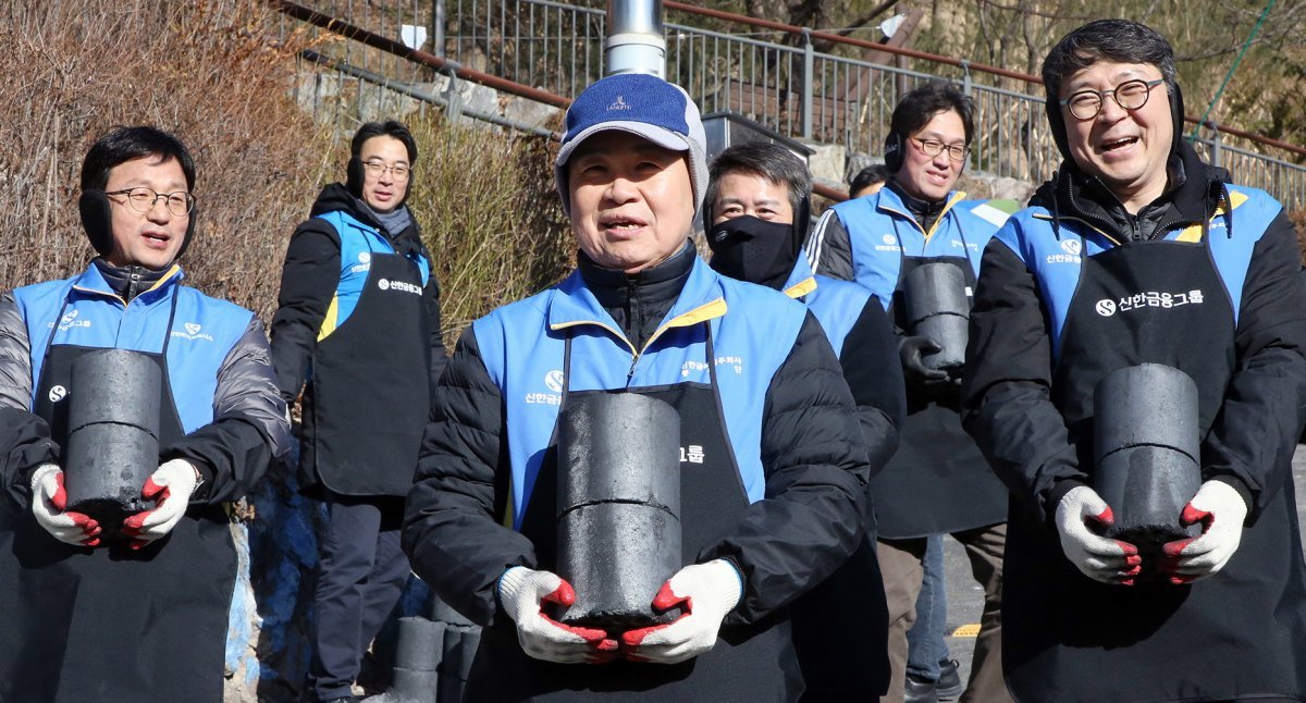 1월 25일 ‘사랑의 연탄 나눔’ 봉사활동 행사에 참석한 진옥동 신한금융그룹 회장(가운데)이 임직원 봉사자들과 함께 연탄을 나르고 있다. 신한금융그룹 제공