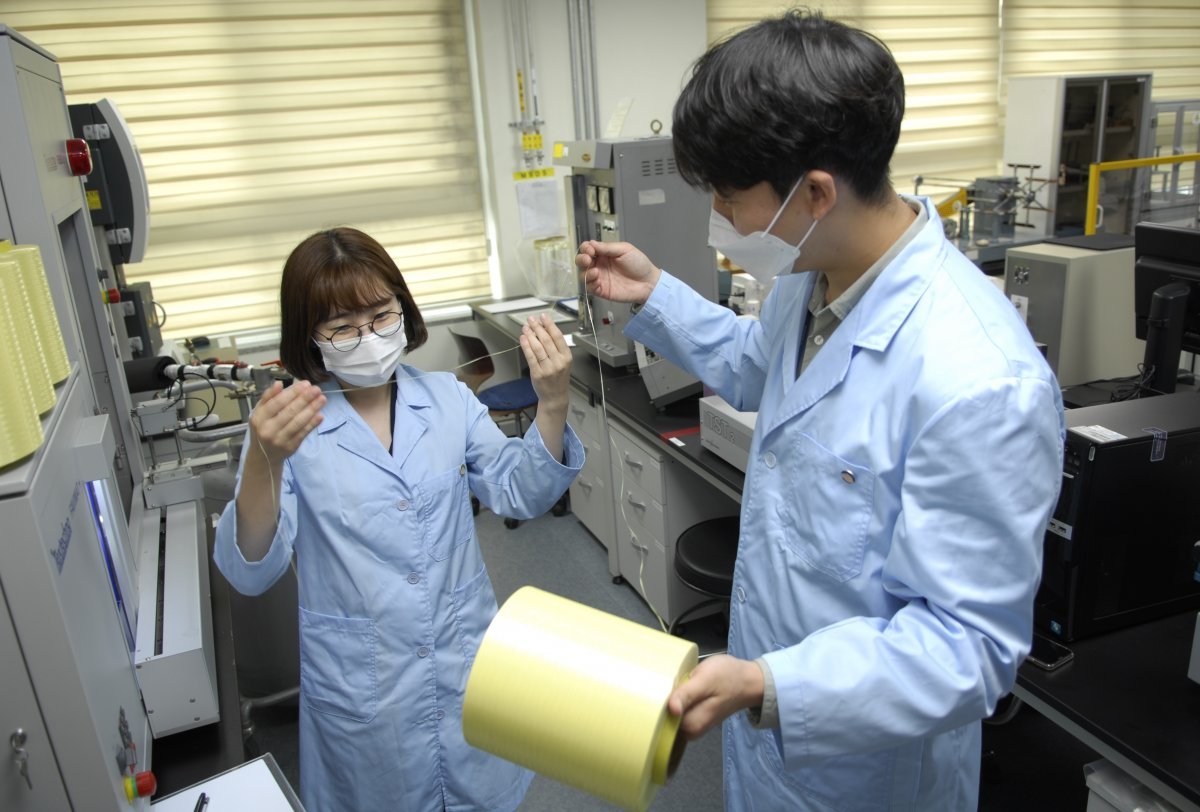 코오롱인더스트리의 연구원들이 아라미드 섬유인 헤라크론 제품을 살펴보고 있다. 코오롱그룹 제공