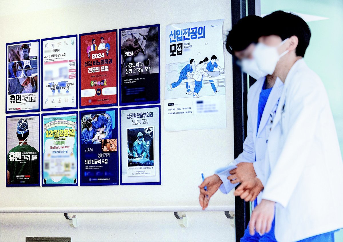 2일 오전 서울의 한 대학병원 전공의 전용공간 앞으로 마스크를 쓴 의료진이 걸어가고 있다. 벽에는 신입 전공의를 모집한다는 
포스터가 붙어 있다. 보건복지부에 따르면 인턴 수련 과정 등록 마감일인 이날까지 등록을 신청한 인턴 예정자는 12%에 불과한 
것으로 나타났다. 뉴스1
