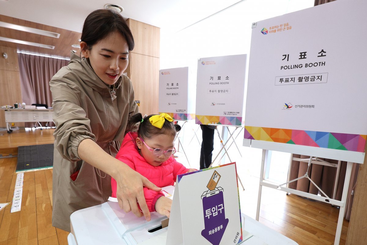 제22대 국회의원선거(총선) 사전투표 첫날인 5일 서울 영등포구 여의동주민센터에 마련된 제22대 국회의원선거 사전투표소에서 어머니가 딸과 함께 투표를 하고 있다. 2024.4.5. 뉴스1